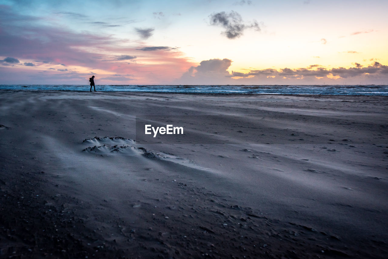 Scenic view of beach against sky during sunset