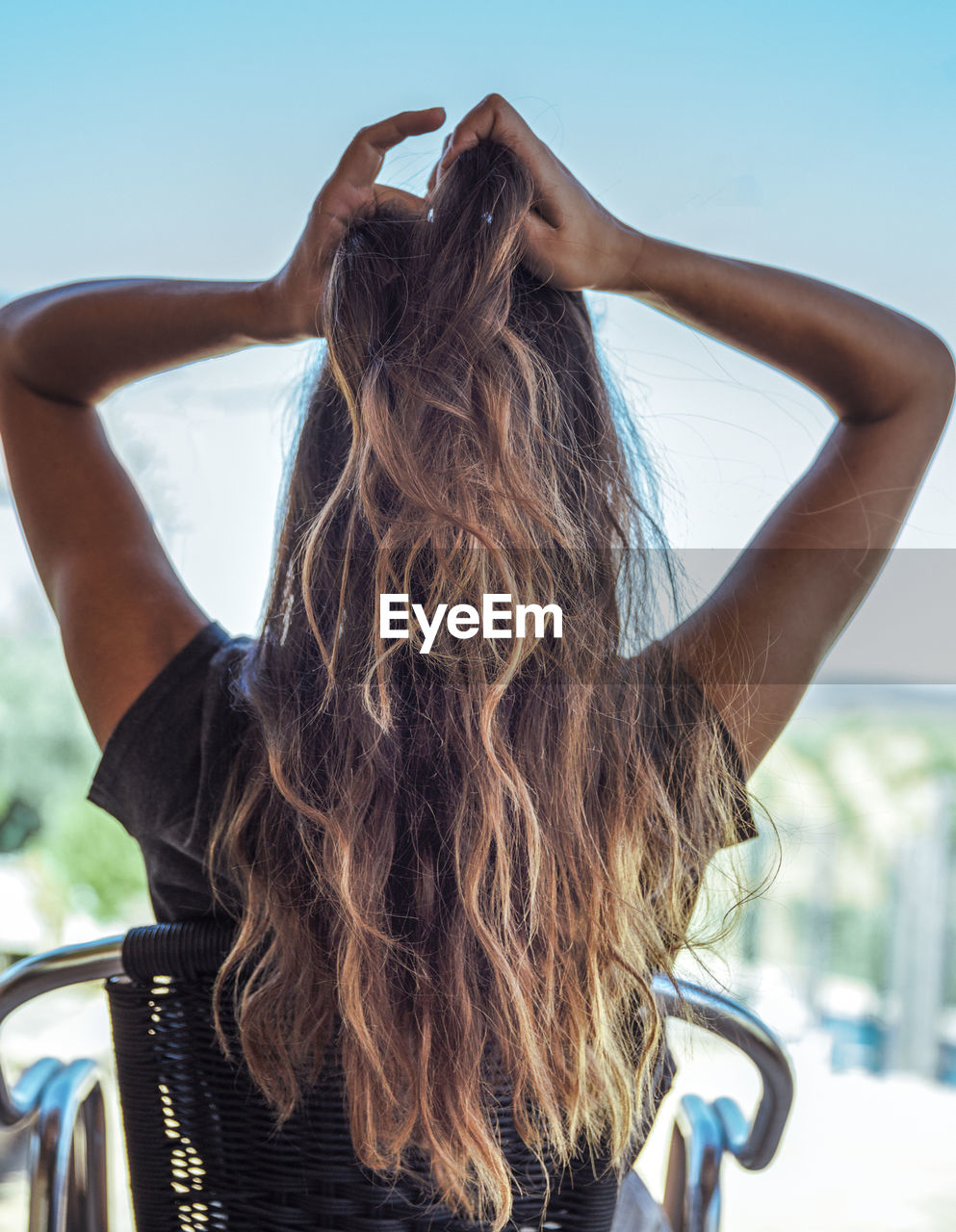 Rear view of young woman against sky