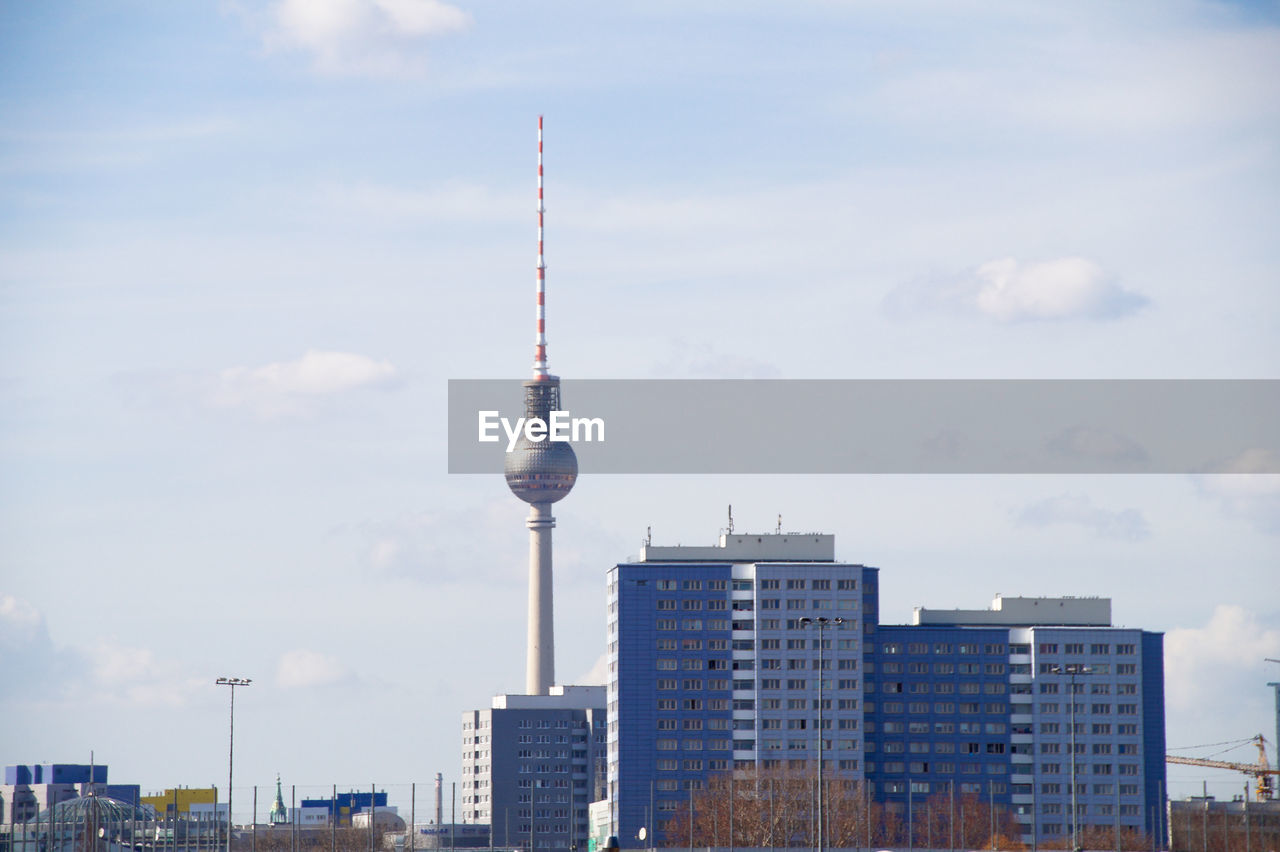 Distant view of fernsehturm in city against sky
