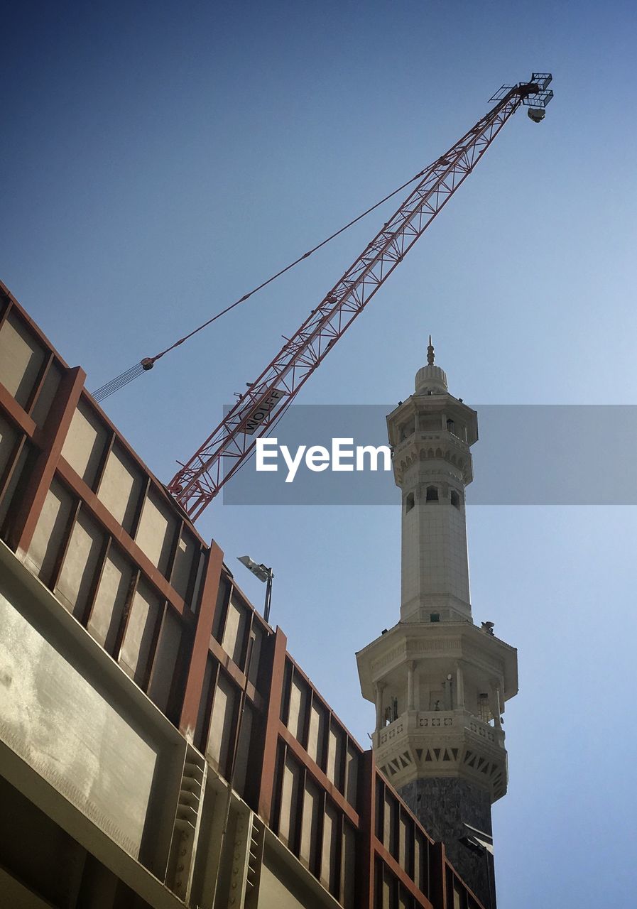 LOW ANGLE VIEW OF CRANE AGAINST BUILDING