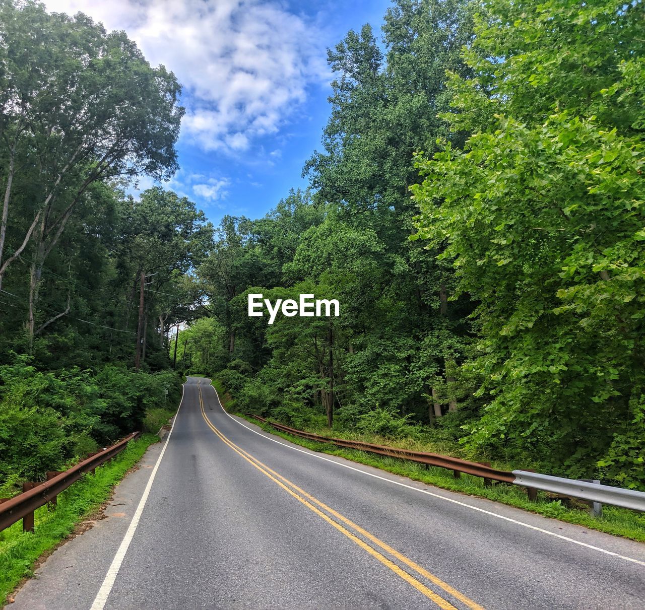 Lonely road disappearing into happy sky