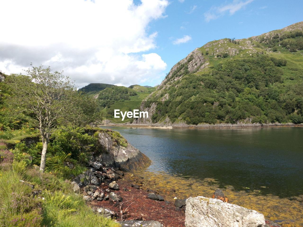 Scenic view of lake against cloudy sky