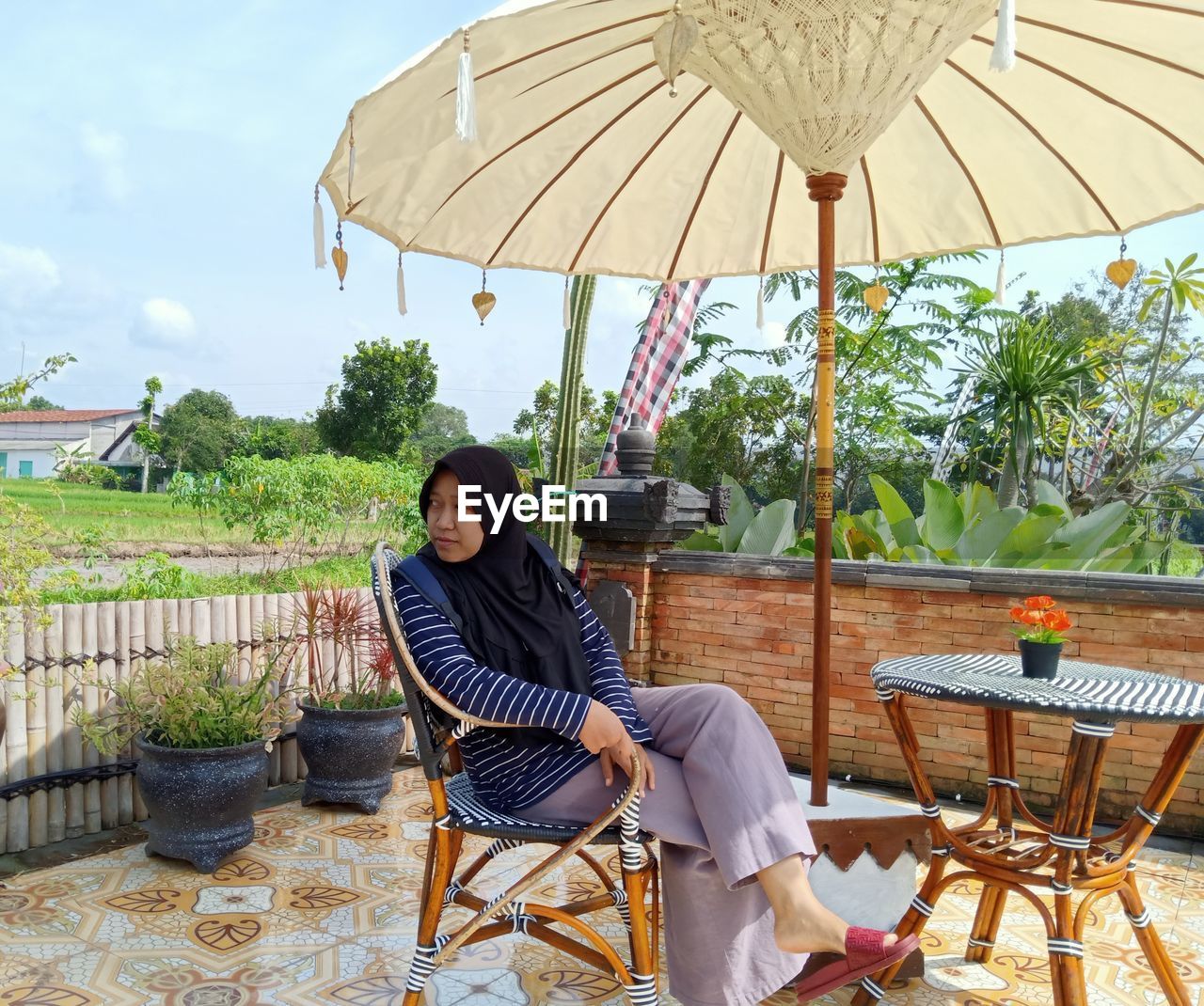 adult, chair, one person, relaxation, sitting, seat, nature, table, umbrella, full length, leisure activity, women, lifestyles, casual clothing, sky, day, sunshade, young adult, parasol, trip, food and drink, vacation, outdoors, plant, enjoyment, architecture, clothing, summer, happiness, tree, protection, smiling, tourist resort, fashion accessory, patio, person, outdoor chair, holiday, travel destinations, business, emotion, sunlight, backyard, weekend activities, tranquility, food, water, furniture, travel, cafe, female