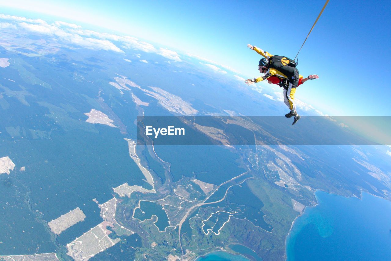 People skydiving over landscape