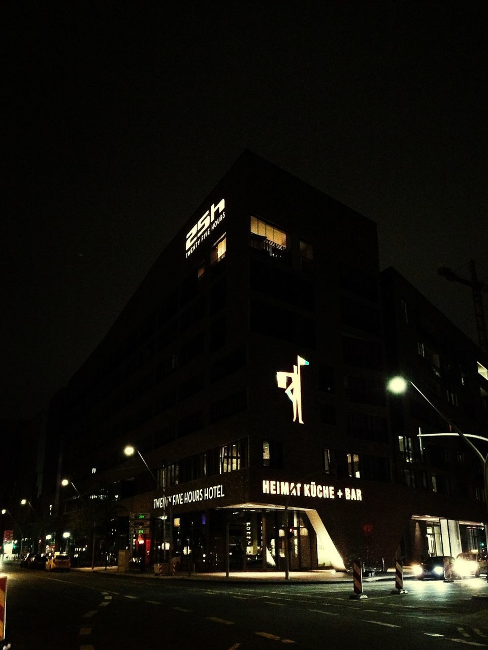 ROAD PASSING THROUGH ILLUMINATED CITY AT NIGHT