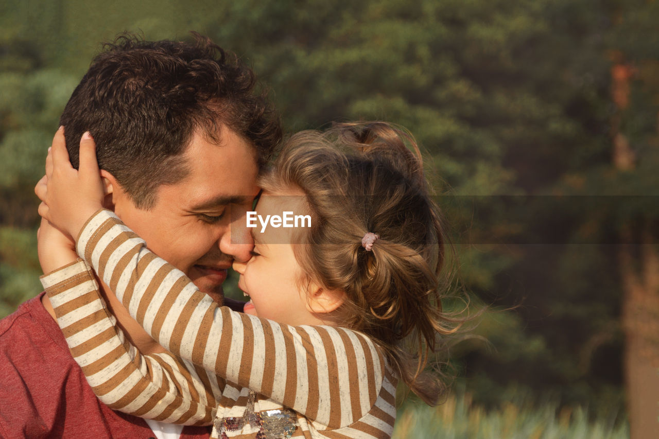 Close-up of father embracing with daughter outdoors