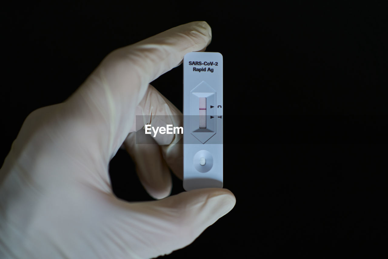 Gloved hand holding coronavirus test - antigen - lateral flow