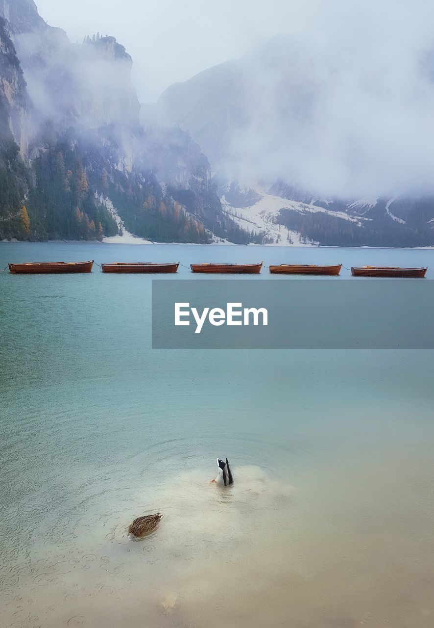 View of boats on lake against mountain range