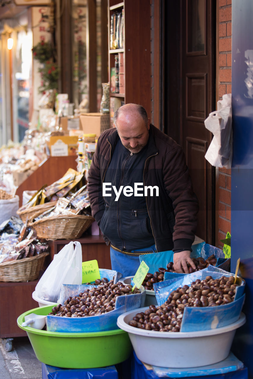 MAN WITH VEGETABLES IN MARKET