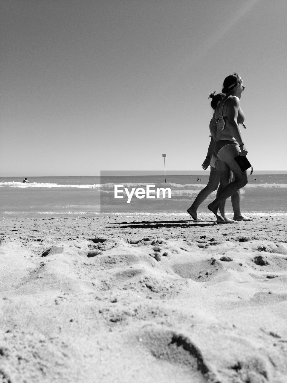 FRIENDS ON BEACH AGAINST CLEAR SKY