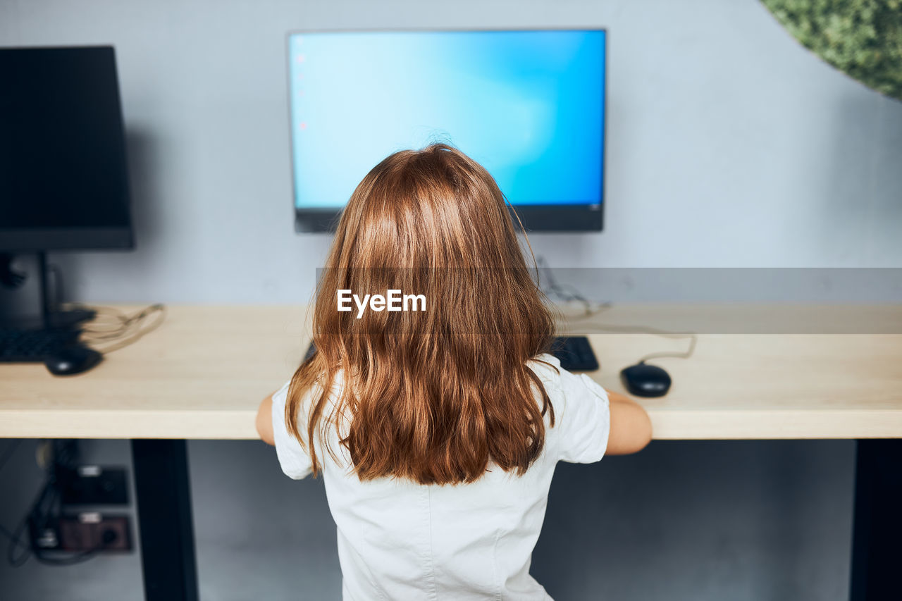 Child learning to use technology in classroom at primary school. student using computer on class