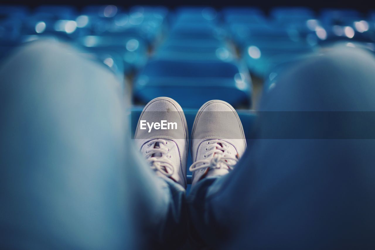 Low section of man sitting on chair at stadium