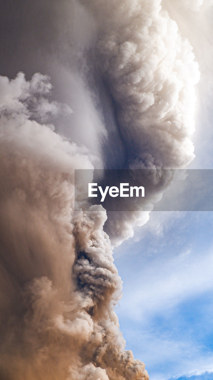 Smoke emitting from volcanic mountain against sky 