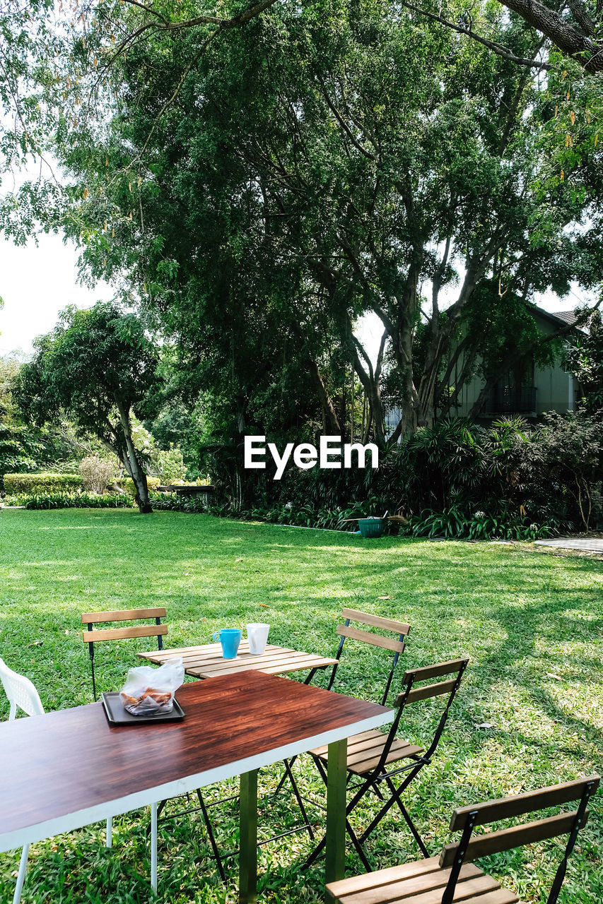 Empty chairs and table in park