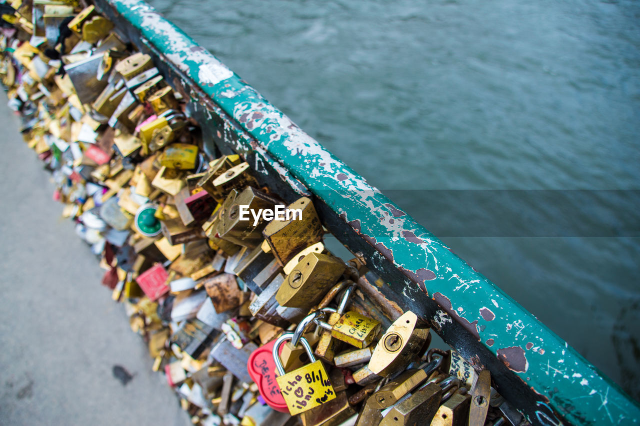 High angle view of padlocks on bridge over river