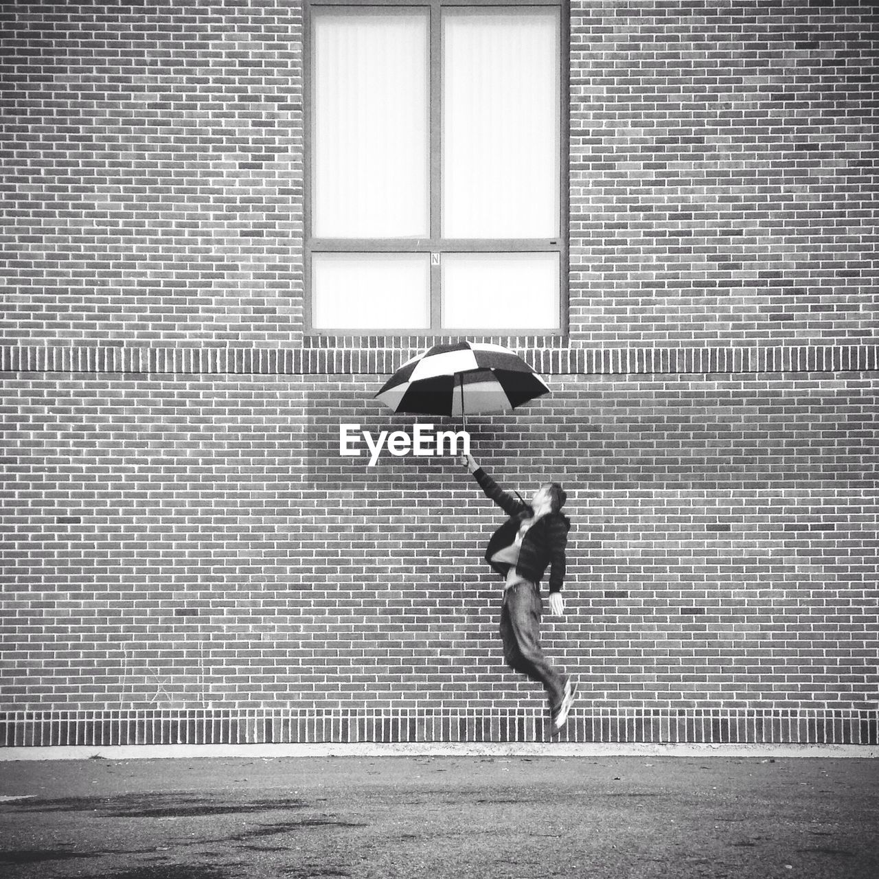 YOUNG MAN WALKING ON BRICK WALL