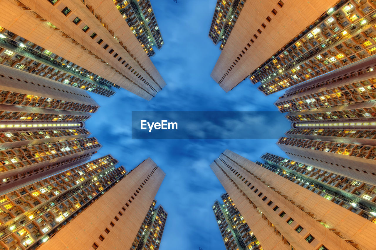 Low angle view of illuminated buildings against sky in city