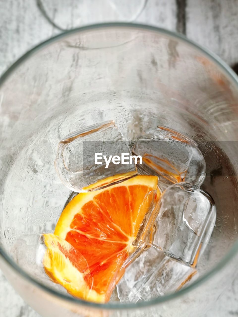 HIGH ANGLE VIEW OF ORANGE ON ICE