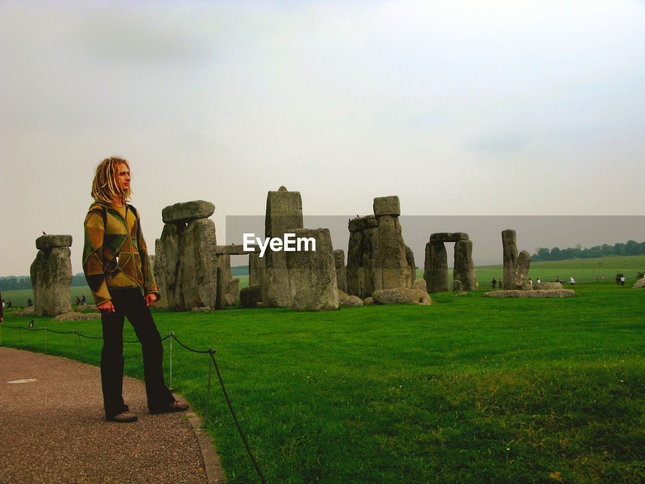 Young man with blonde dreadlocks at stonehenge.