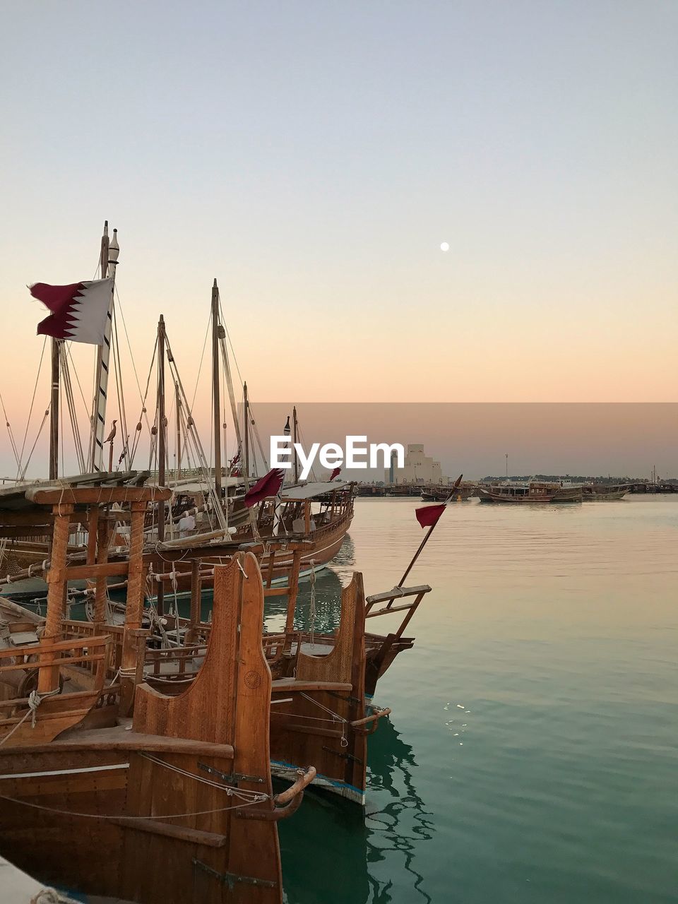 SAILBOATS MOORED AT HARBOR AGAINST SKY