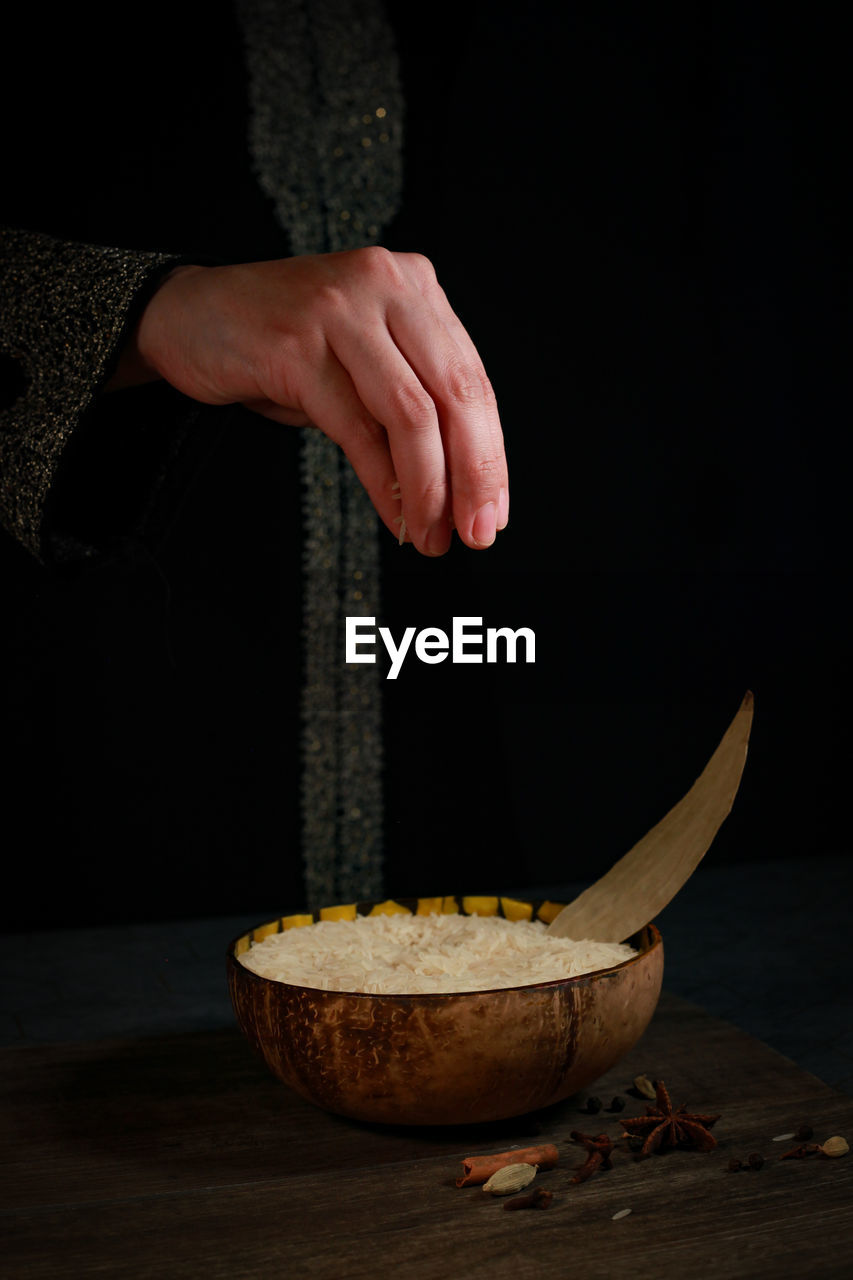 CLOSE-UP OF HAND HOLDING BOWL