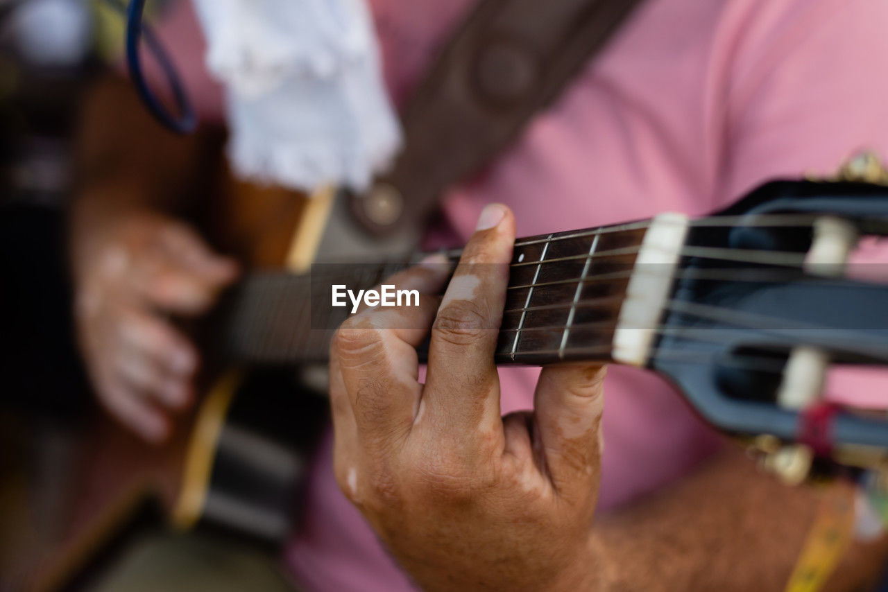 Detail of hands playing a guitar with nylon strings. professional musician.