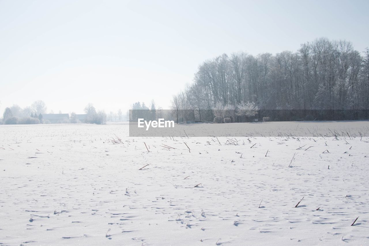 Snow covered landscape against clear sky