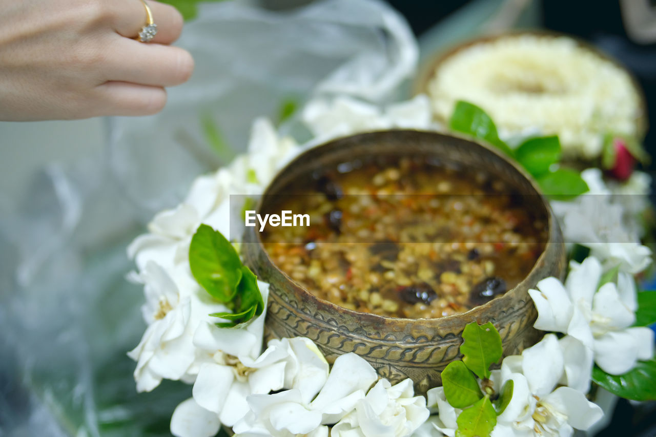 Close-up of food in bowls with white flowers on table