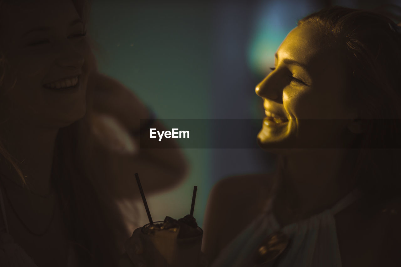Close-up of female friends having drink outdoors