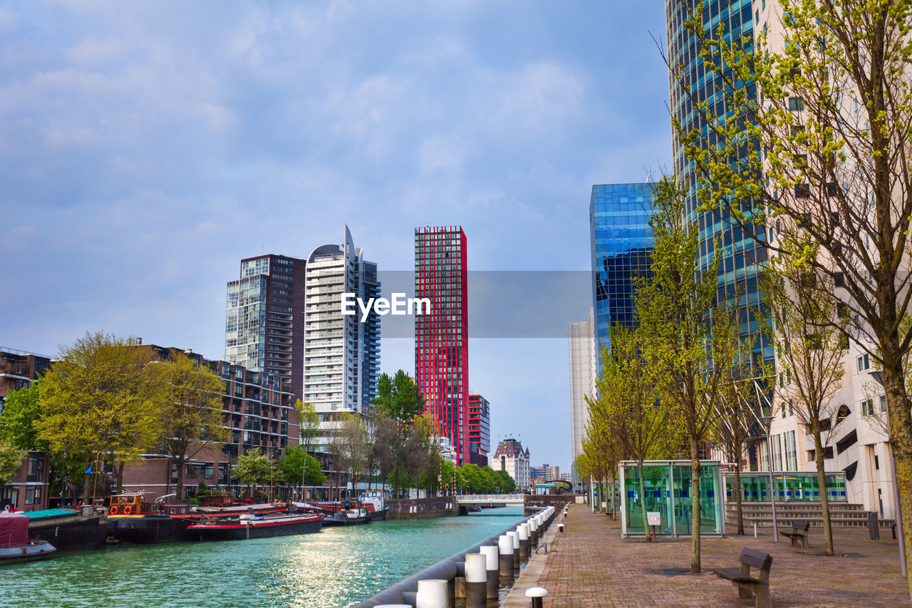 BUILDINGS BY RIVER AGAINST SKY