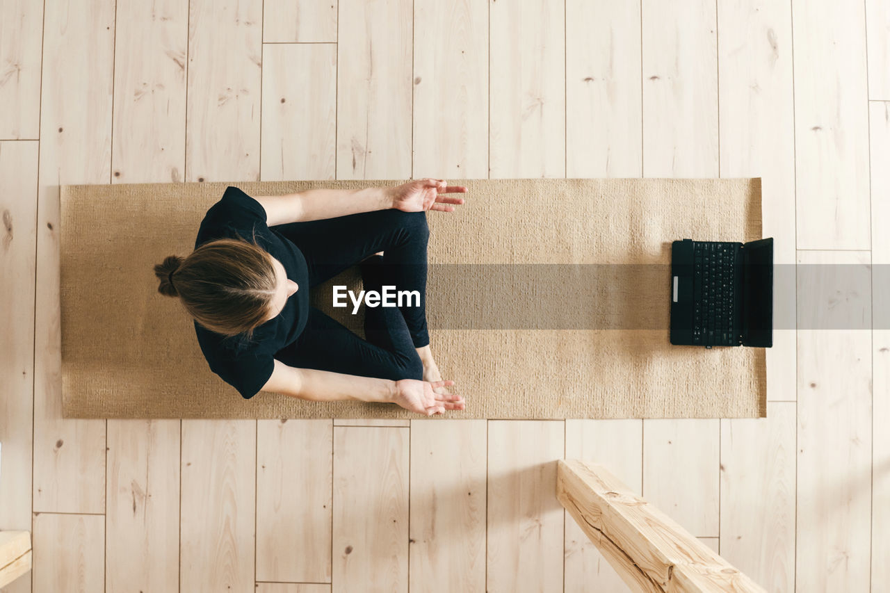 Top view of woman woman practicing yoga indoor.