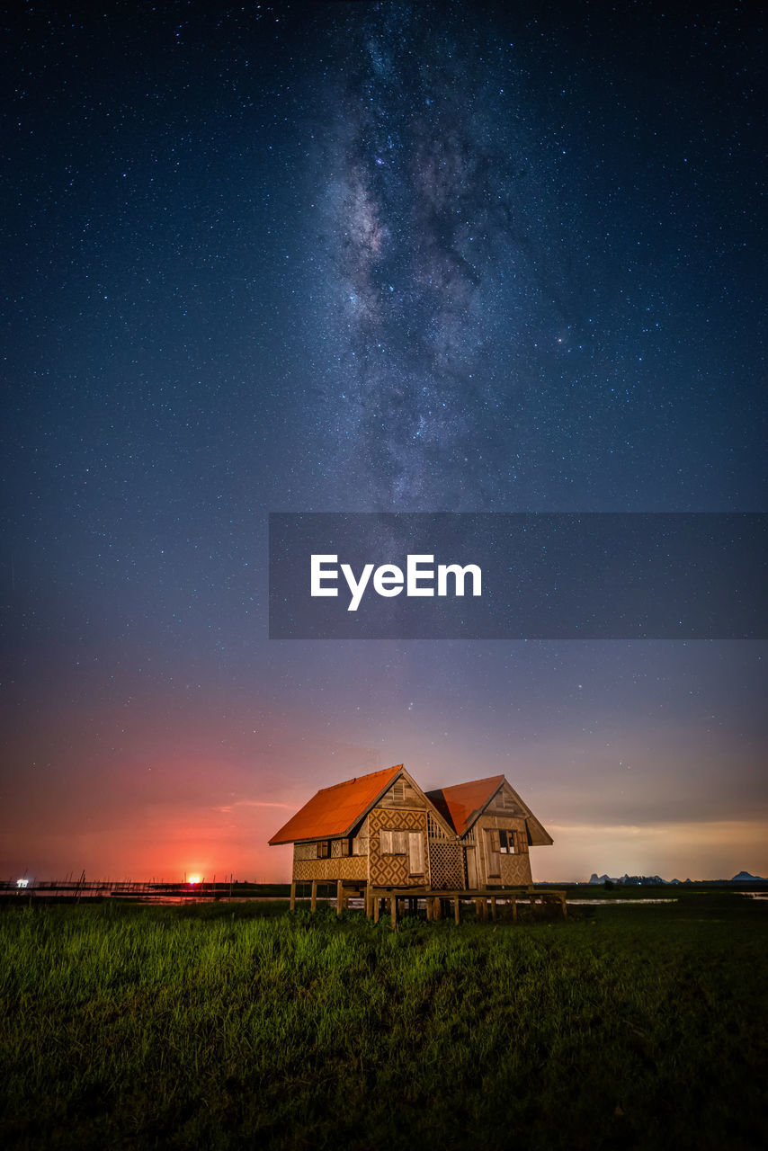 Built structure on field against sky at night