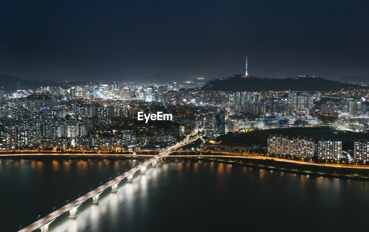 Illuminated cityscape against sky at night