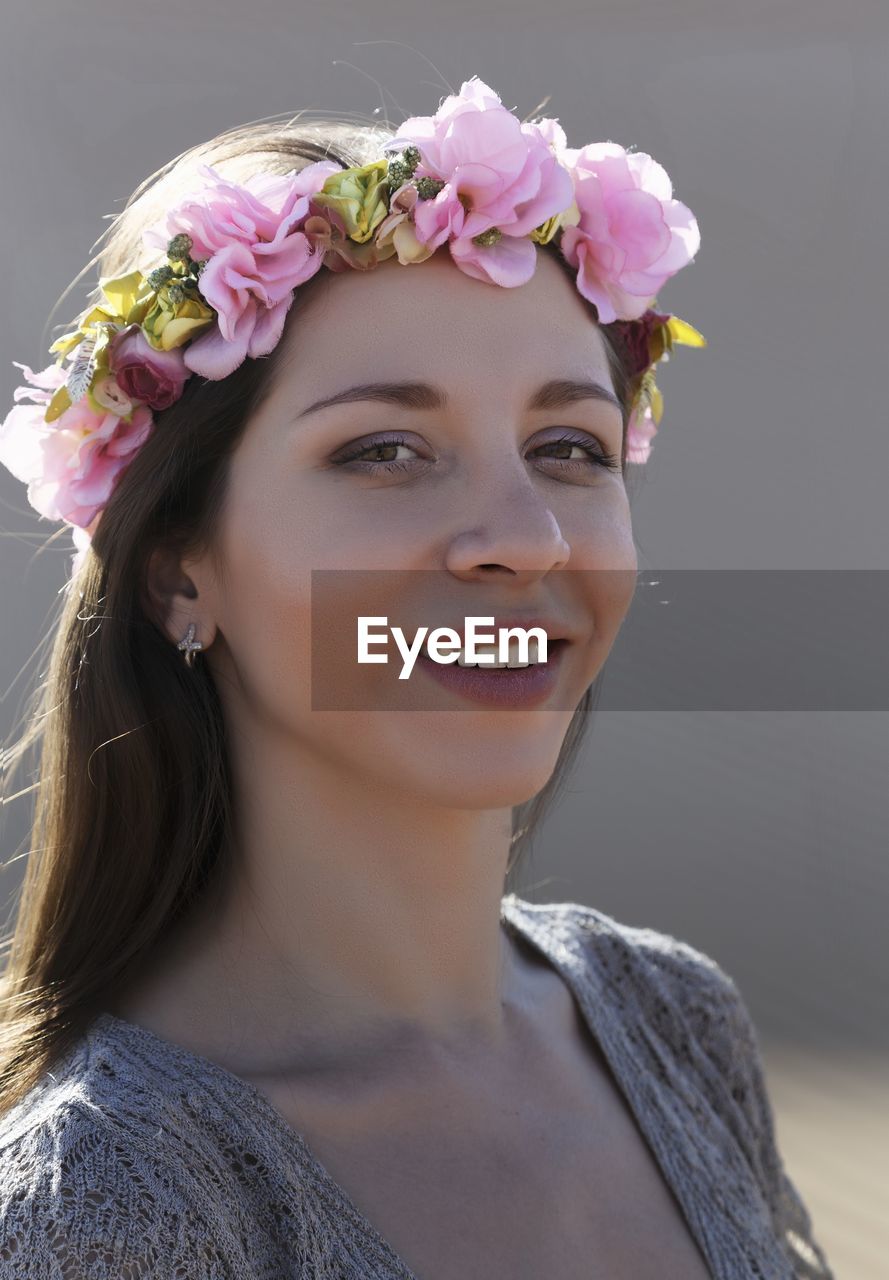 Close-up portrait of smiling young woman wearing flowers