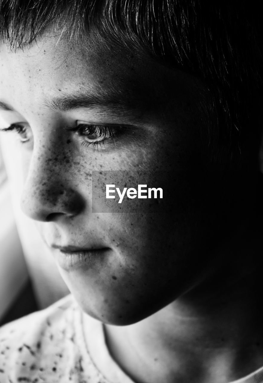 Close-up of man with freckles looking away