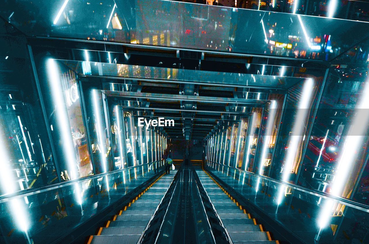 High angle view of woman on illuminated escalator