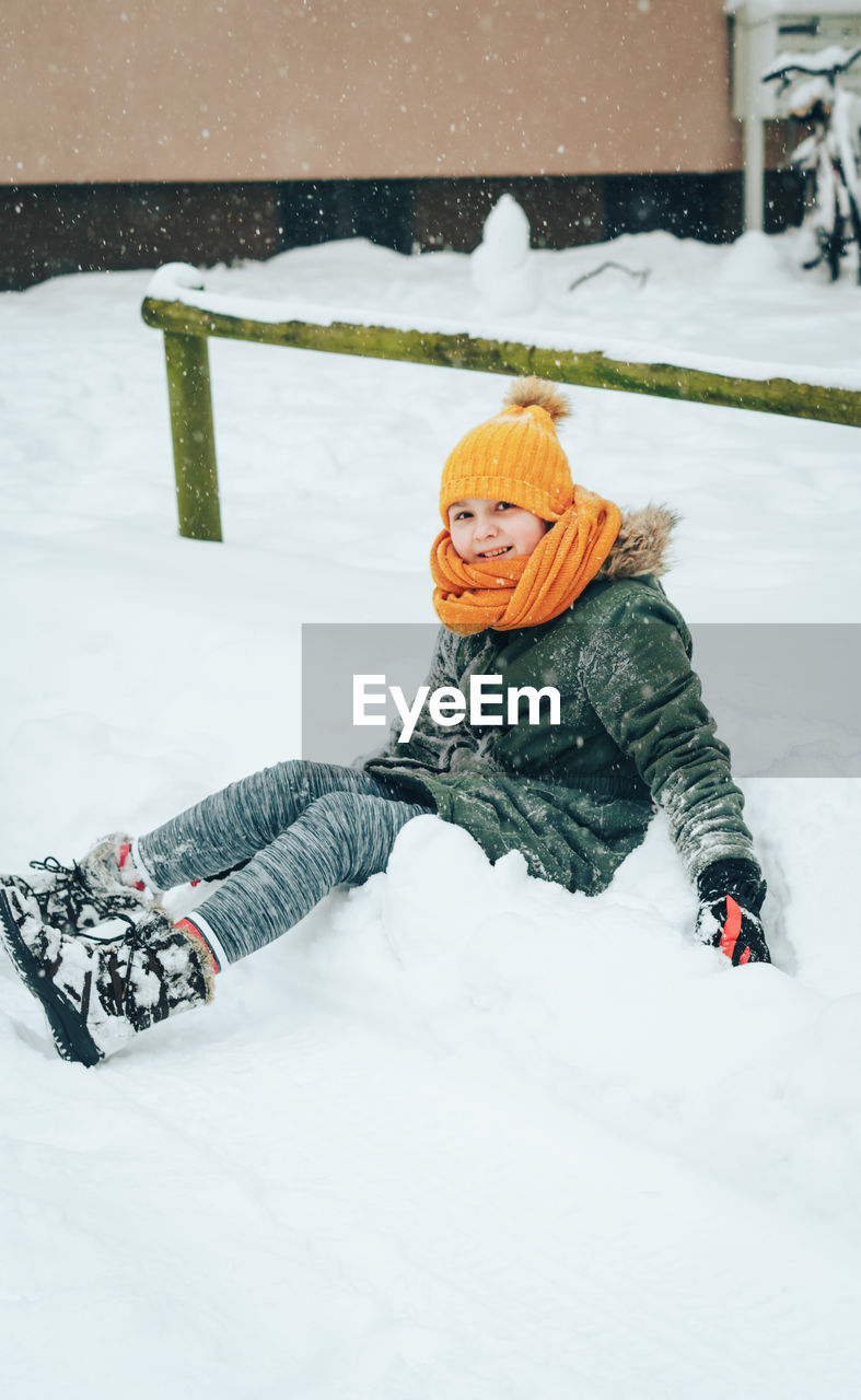 Girl playing on snow covered field during winter