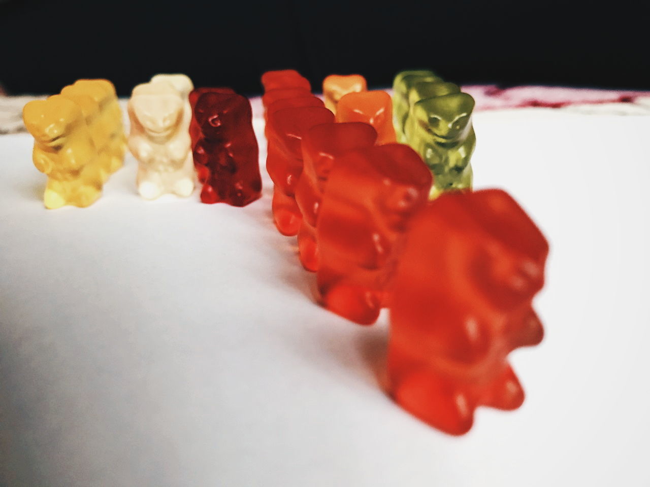 CLOSE-UP OF MULTI COLORED CANDIES AGAINST WHITE BACKGROUND