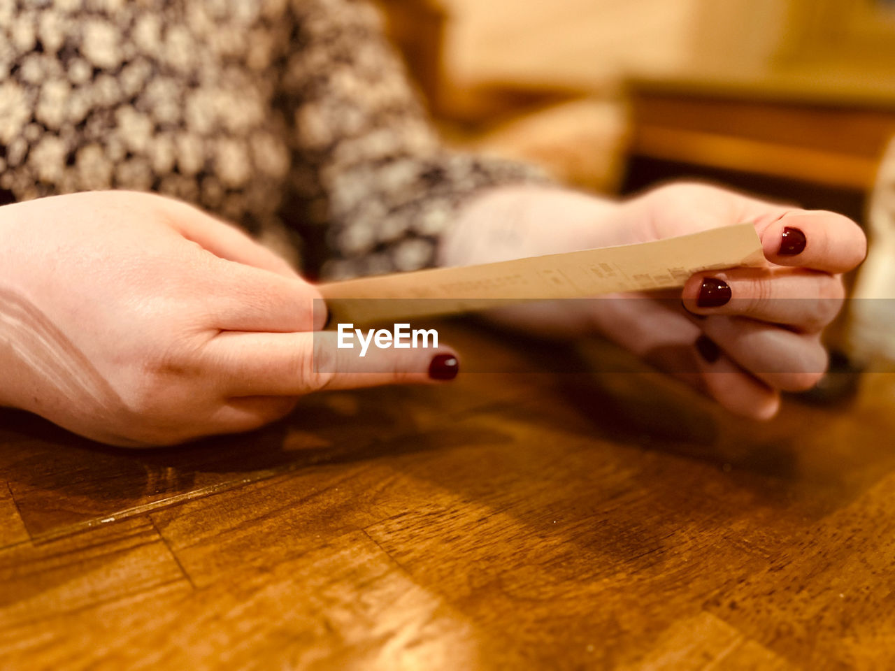 hand, finger, one person, adult, nail, indoors, wood, writing, close-up, women, human leg, holding, manicure, ring, selective focus, craft, table, limb