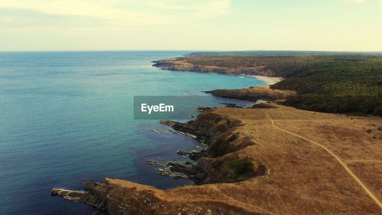 SCENIC VIEW OF SEA BY ROCKS AGAINST SKY