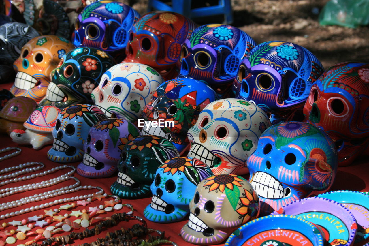 Close-up of multi colored human skulls at market for sale