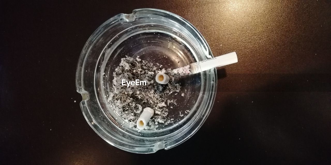 CLOSE-UP HIGH ANGLE VIEW OF CIGARETTE ON TABLE