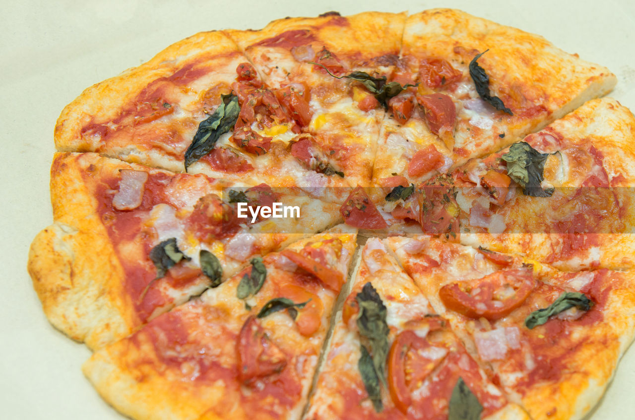 CLOSE-UP OF PIZZA AGAINST WHITE BACKGROUND