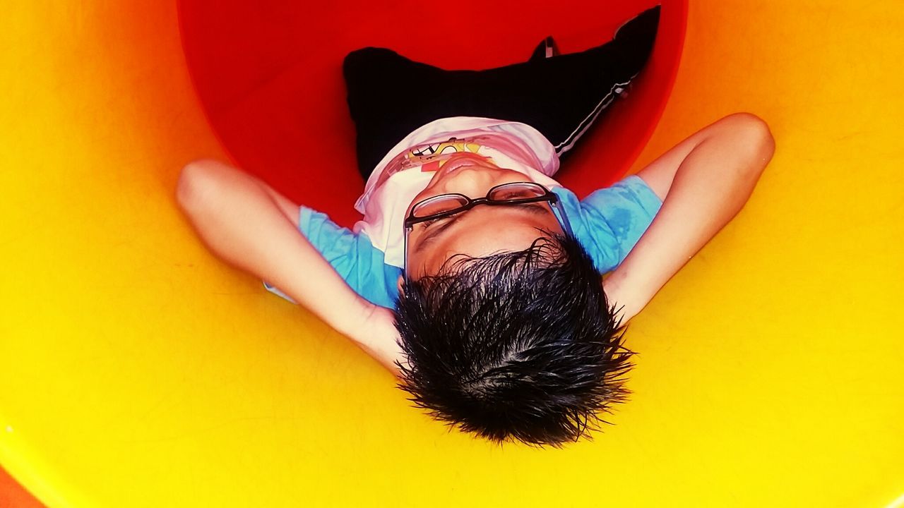 Close-up of cute boy playing in slide tunnel