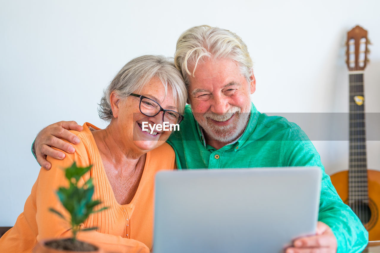 PORTRAIT OF HAPPY MAN USING SMART PHONE