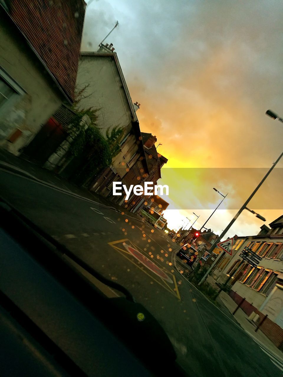 CARS PARKED ON STREET AGAINST CLOUDY SKY