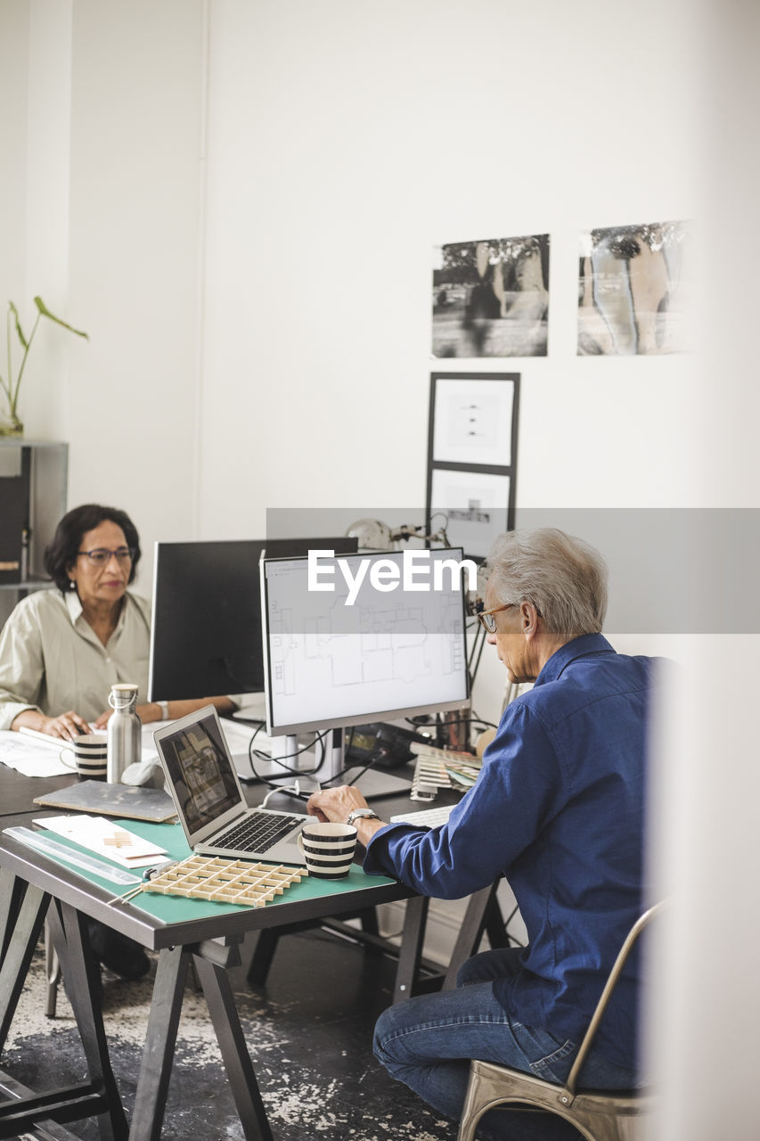 Female and male colleagues working on computer in office