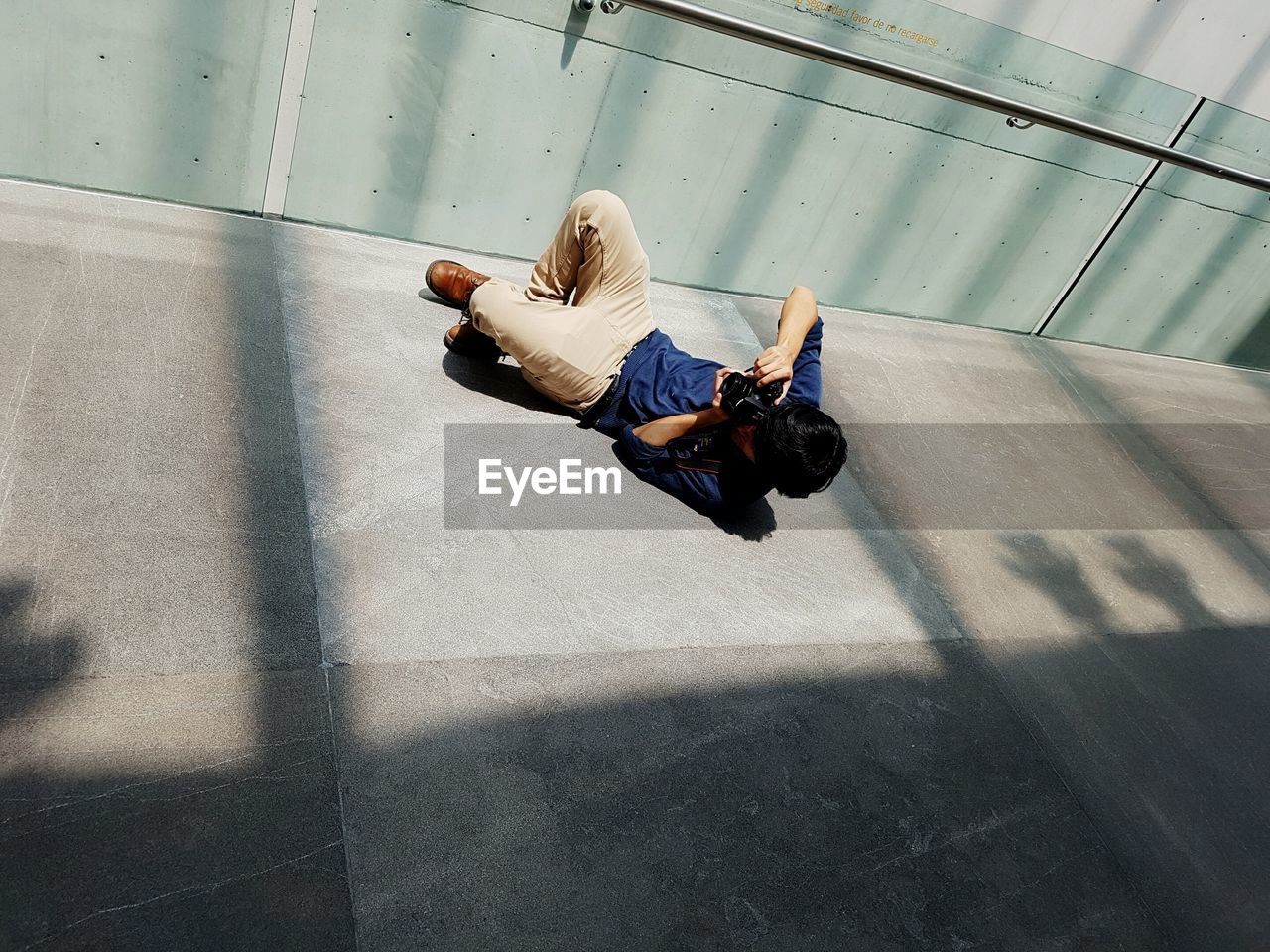 HIGH ANGLE VIEW OF MAN WITH SHADOW ON FLOOR