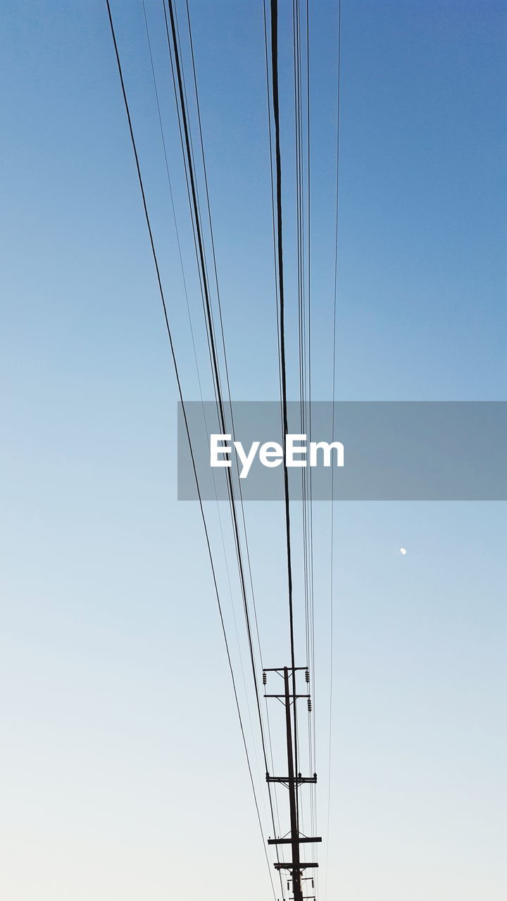 Low angle view of electric pole against clear sky