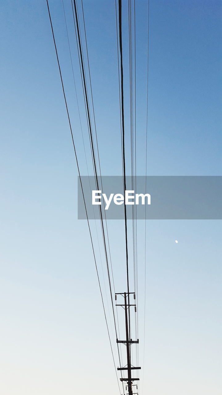Low angle view of electric pole against clear sky